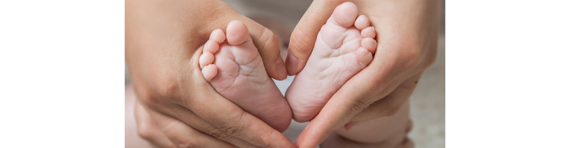 Small newborn baby legs in mothers lovely hand with soft focus on babie's foot