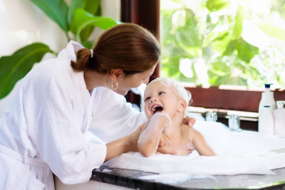 caregiver bathing a baby